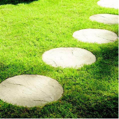 Round pavers used as stepping stones across a lawn
